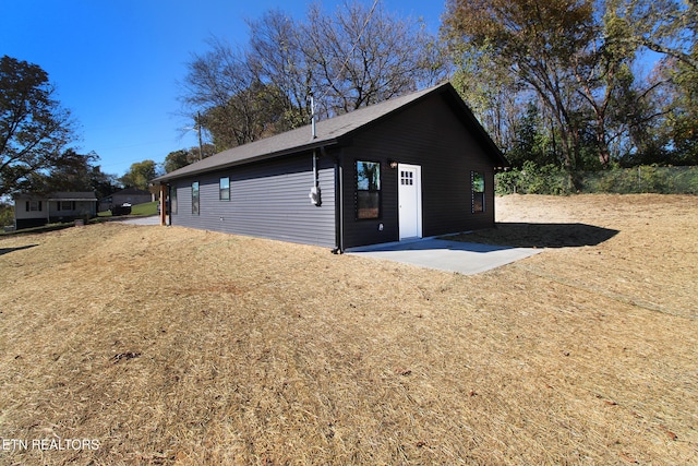 view of side of property with a yard and a patio area