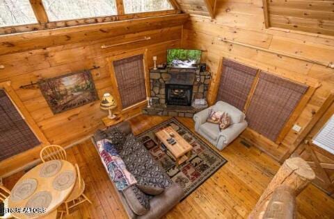 living room featuring wood walls, wood-type flooring, and a fireplace