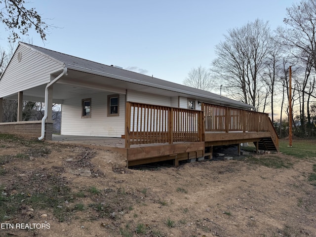 back house at dusk with a deck