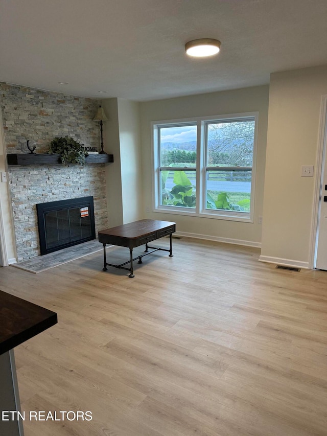 living room with light hardwood / wood-style flooring and a fireplace