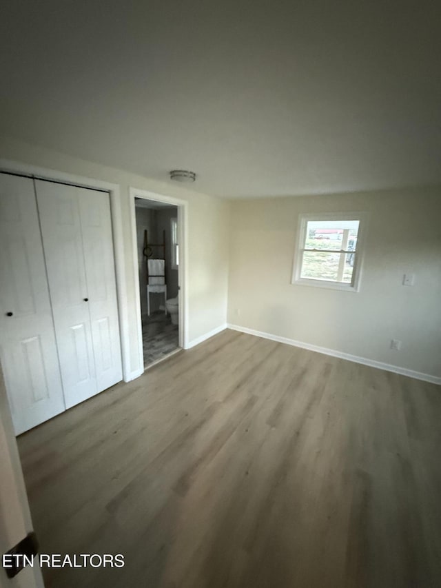 1184 Davis Chapel Rd, Lafollette, TN 37766 - unfurnished bedroom featuring wood finished floors, baseboards, connected bathroom, and a closet