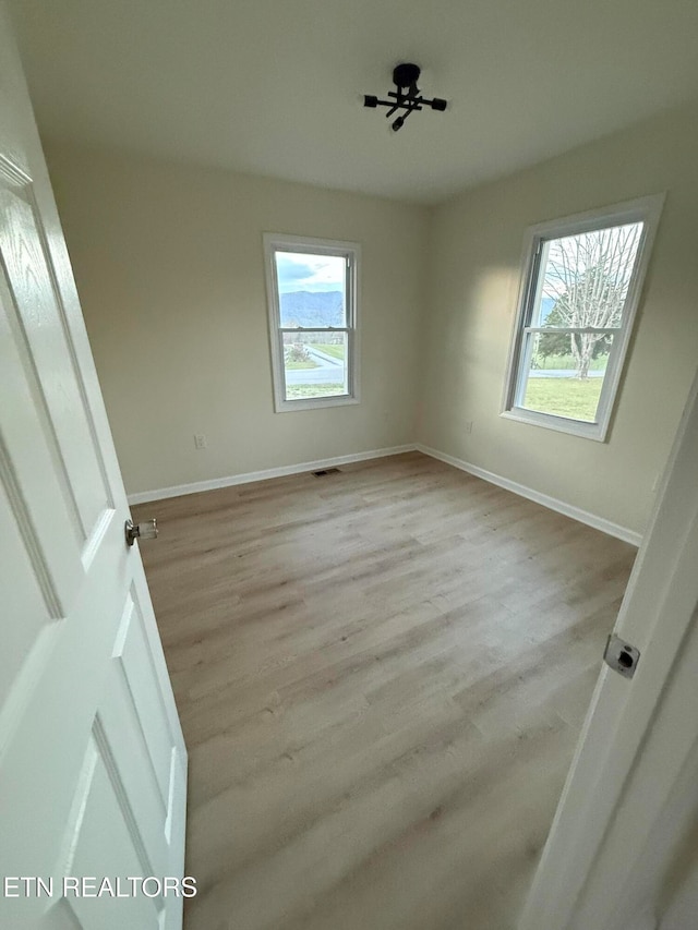 unfurnished room with ceiling fan, a healthy amount of sunlight, and light hardwood / wood-style flooring