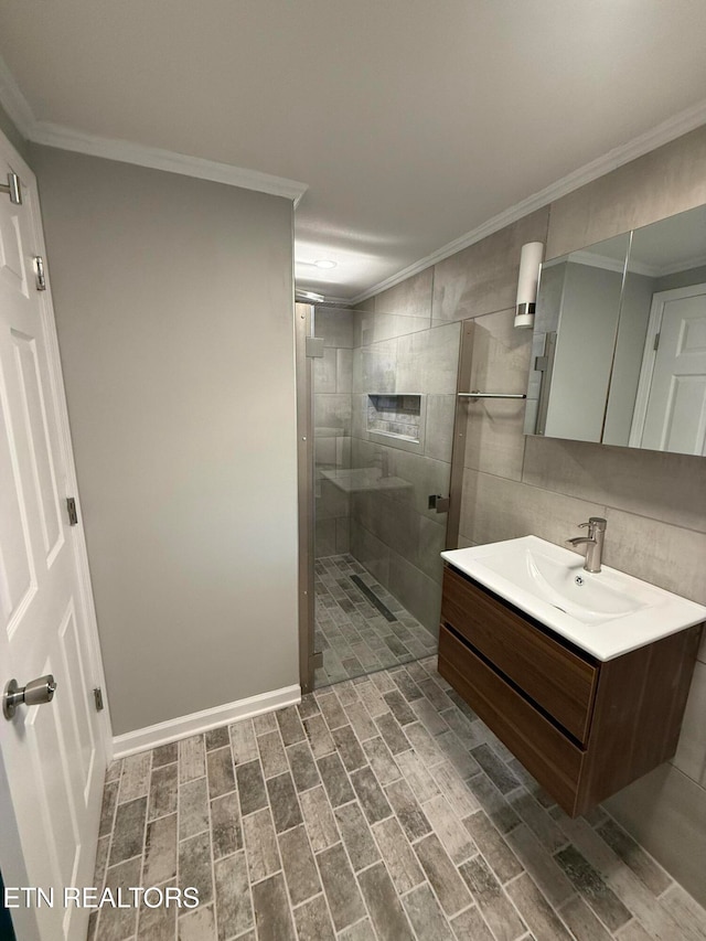 bathroom with vanity, wood-type flooring, crown molding, and tiled shower