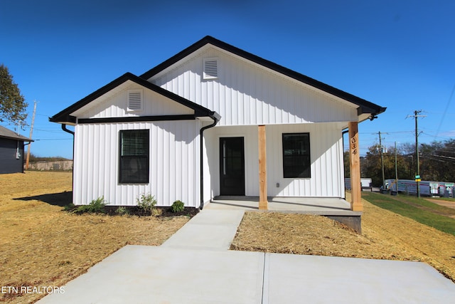 modern inspired farmhouse featuring a front lawn and a porch