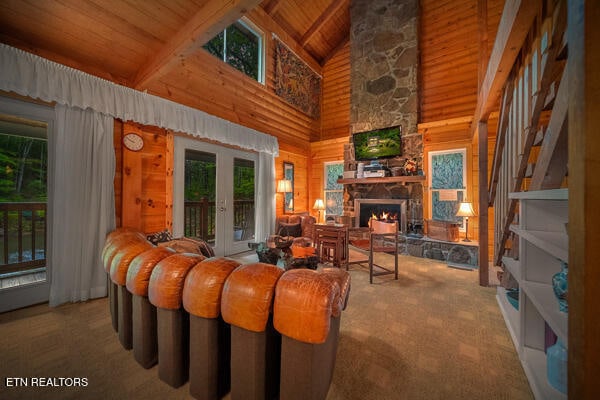 living room with high vaulted ceiling, beamed ceiling, carpet floors, a fireplace, and wood ceiling