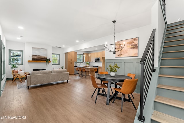 dining area with plenty of natural light, a notable chandelier, and light hardwood / wood-style floors