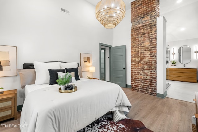 bedroom with a high ceiling and light wood-type flooring