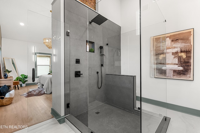 bathroom featuring wood-type flooring, a chandelier, and a shower with shower door