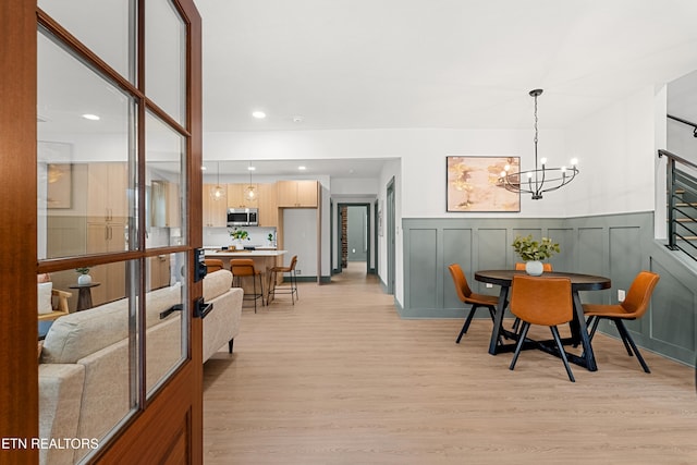 dining room featuring a notable chandelier and light hardwood / wood-style flooring