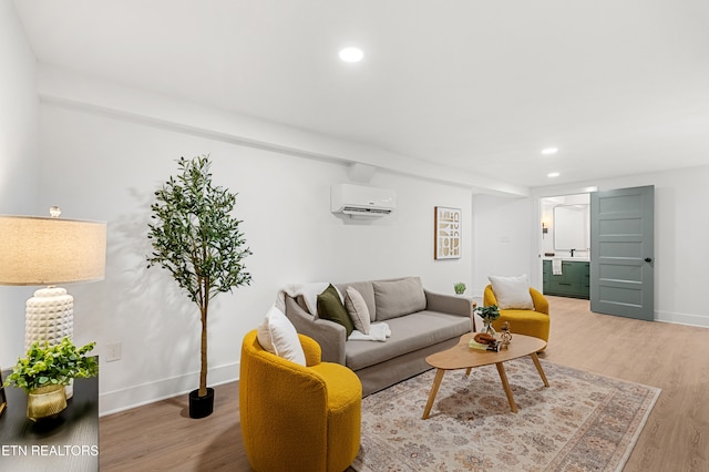 living room with a wall unit AC and light hardwood / wood-style floors