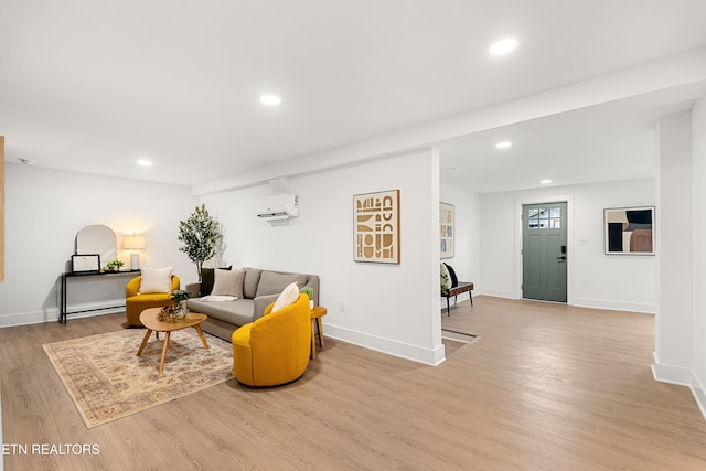 living room featuring an AC wall unit and light wood-type flooring