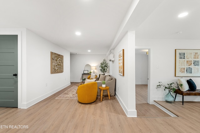 hallway with light wood-type flooring and a wall unit AC