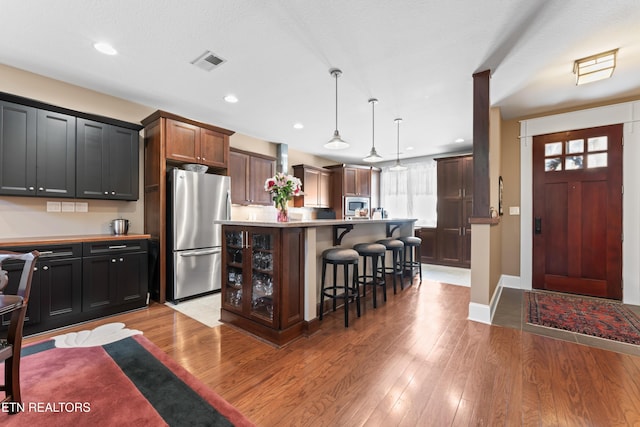 1144 Andalusian Way, Knoxville, TN 37922 - kitchen featuring appliances with stainless steel finishes, a kitchen bar, light wood-type flooring, light countertops, and a center island