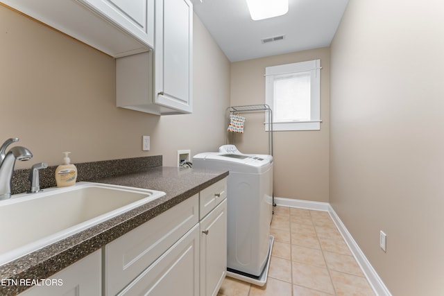 washroom featuring sink, cabinets, washing machine and clothes dryer, and light tile patterned flooring