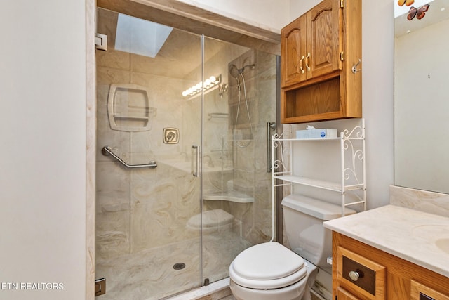 bathroom featuring vanity, toilet, walk in shower, and a skylight