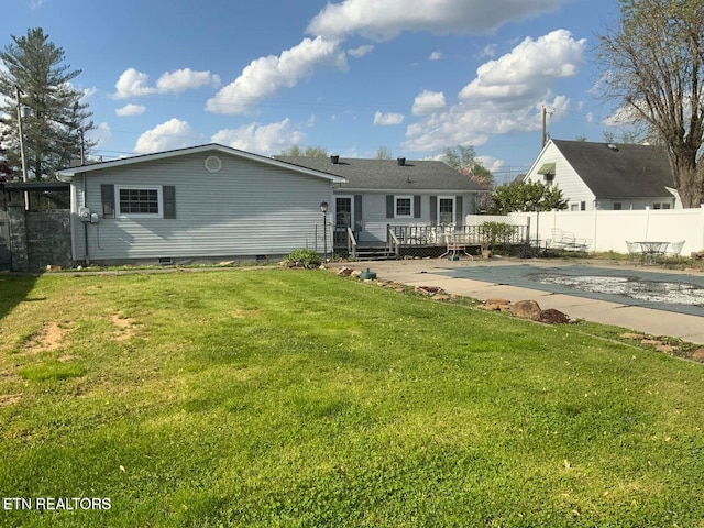 back of house with a wooden deck and a lawn