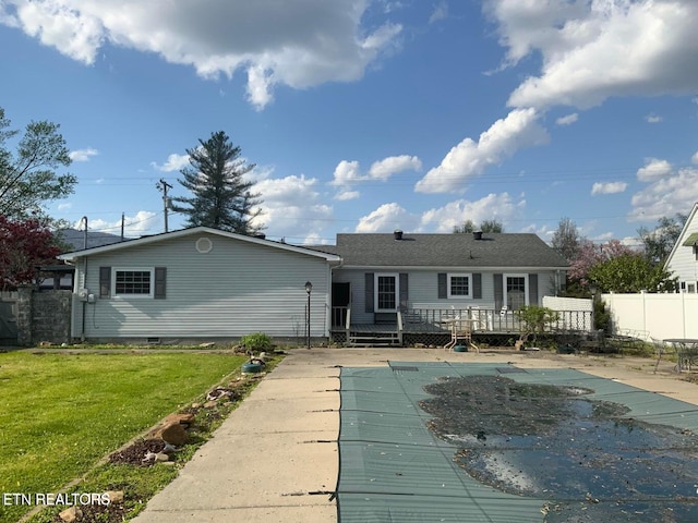 rear view of house with a lawn and a wooden deck