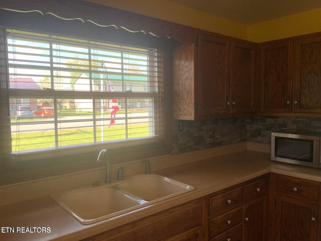 kitchen featuring backsplash, sink, and plenty of natural light