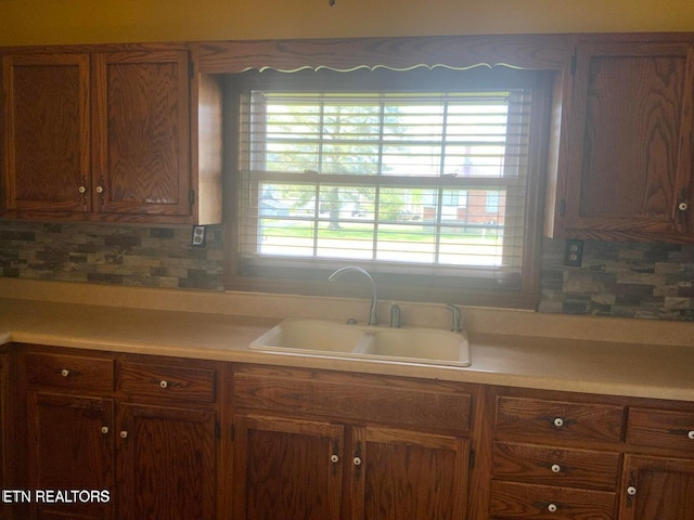 1315 Winchester Ave, Middlesboro, KY 40965 - kitchen featuring a sink, light countertops, tasteful backsplash, and brown cabinetry