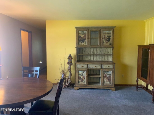 dining space featuring dark carpet