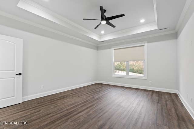 empty room featuring ceiling fan, dark hardwood / wood-style floors, crown molding, and a tray ceiling