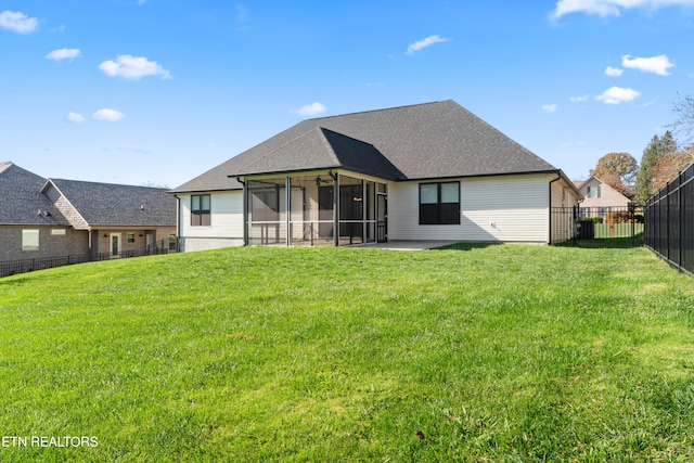 rear view of property with a lawn, a sunroom, and a patio area