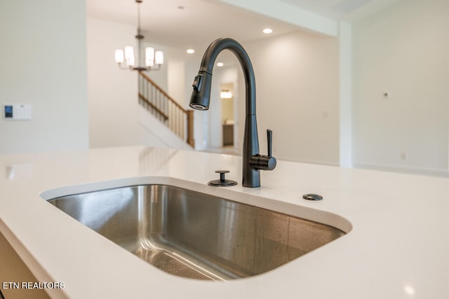 room details featuring a chandelier, sink, and decorative light fixtures