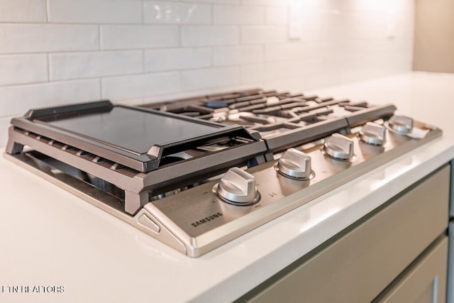 details with stainless steel gas cooktop and backsplash