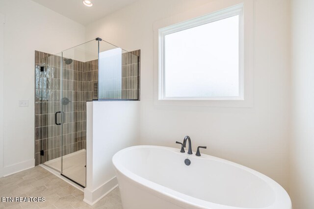 bathroom with a wealth of natural light, tile patterned flooring, and independent shower and bath