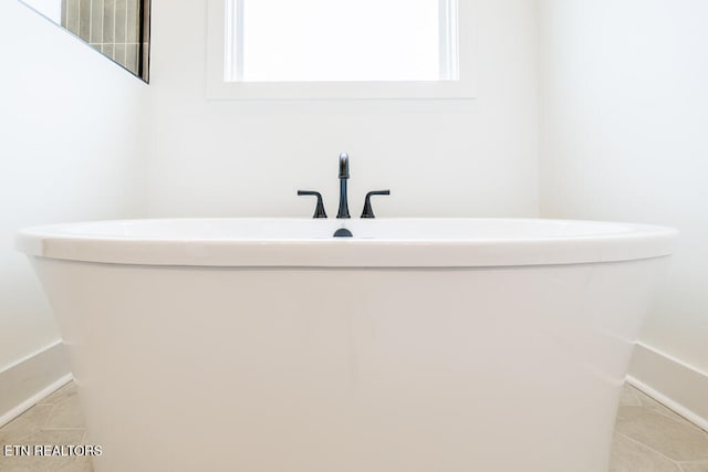 bathroom featuring tile patterned floors and a washtub