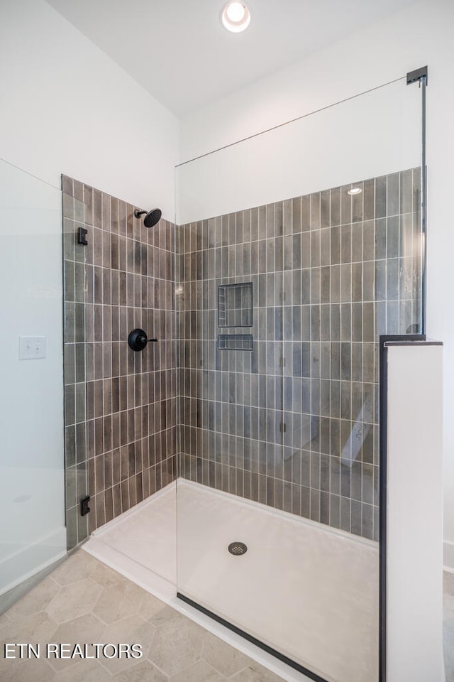 bathroom with tile patterned floors and a tile shower