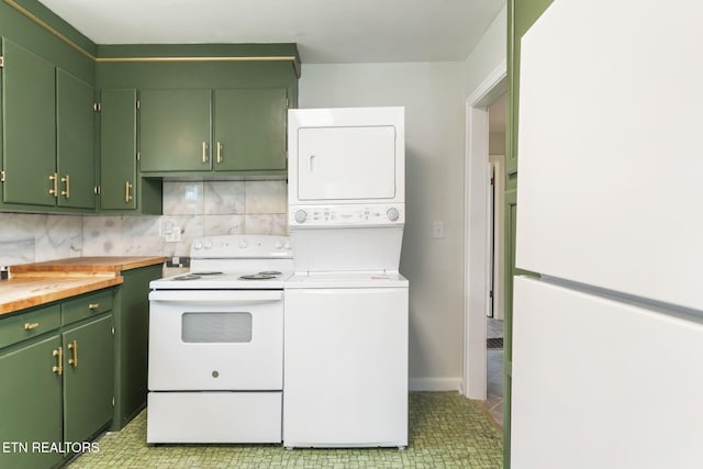 kitchen with light tile patterned flooring, stacked washer and clothes dryer, backsplash, green cabinetry, and white appliances