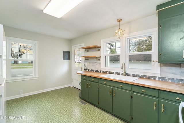 kitchen featuring wooden counters, a wealth of natural light, sink, and green cabinets