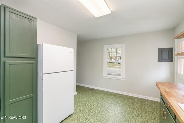 kitchen featuring butcher block counters, golf simulator, green cabinets, and white fridge