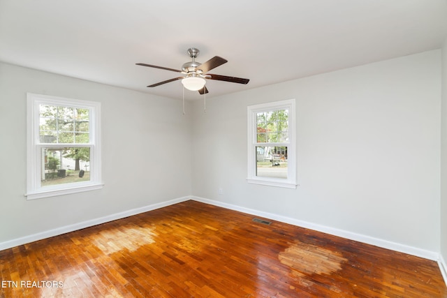 empty room with hardwood / wood-style floors, a wealth of natural light, and ceiling fan