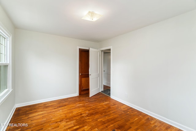 unfurnished room with hardwood / wood-style flooring