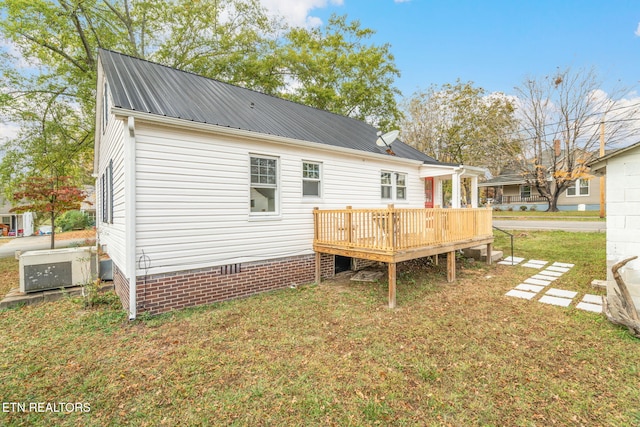 rear view of house featuring a yard and a wooden deck