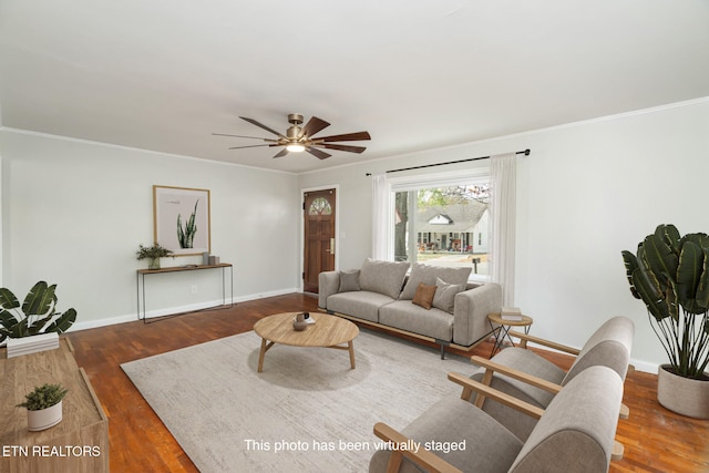 living room featuring dark wood-type flooring, ceiling fan, and crown molding