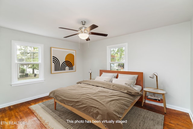 bedroom featuring dark wood-type flooring, multiple windows, and ceiling fan