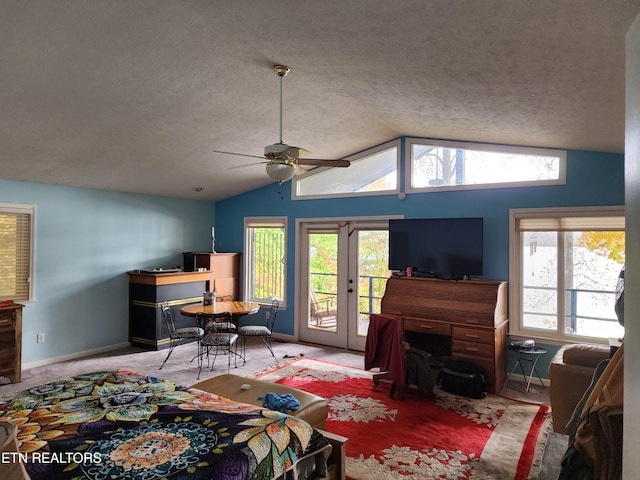 living room featuring a textured ceiling, lofted ceiling, a healthy amount of sunlight, and ceiling fan