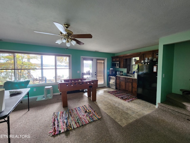 game room featuring french doors, light colored carpet, a textured ceiling, and ceiling fan