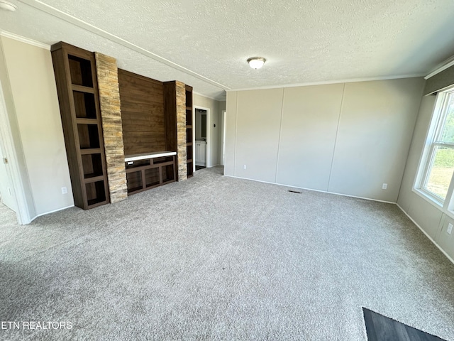 unfurnished living room featuring ornamental molding, a textured ceiling, and carpet