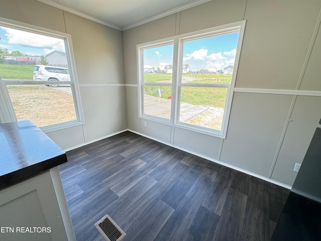 unfurnished dining area featuring dark hardwood / wood-style flooring and ornamental molding