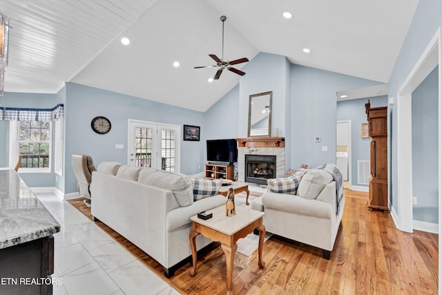 living room featuring ceiling fan, high vaulted ceiling, a healthy amount of sunlight, and light wood-type flooring