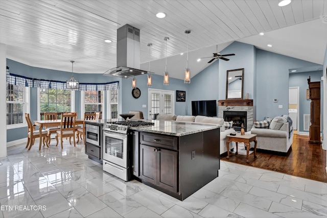 kitchen featuring light stone countertops, stainless steel appliances, island exhaust hood, lofted ceiling, and decorative light fixtures