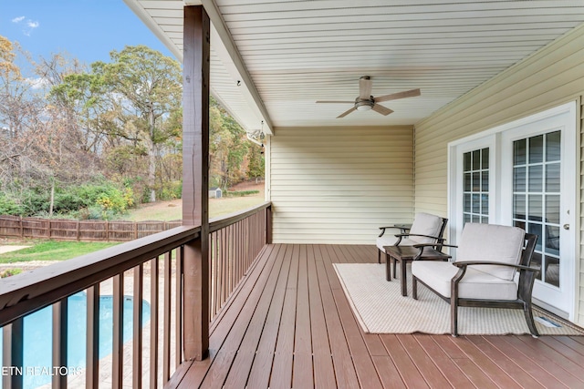 wooden terrace featuring ceiling fan and a swimming pool