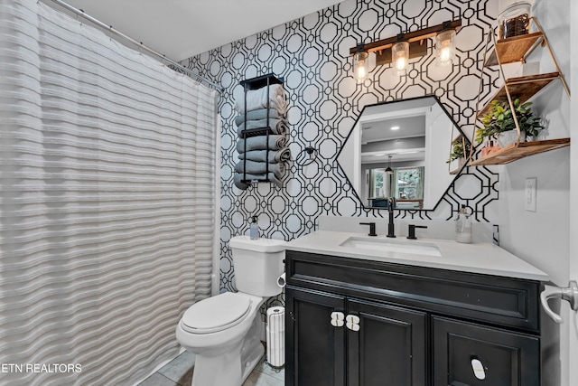 bathroom with toilet, vanity, and tile patterned floors