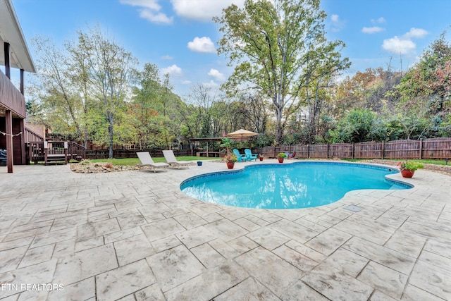 view of pool featuring a wooden deck and a patio