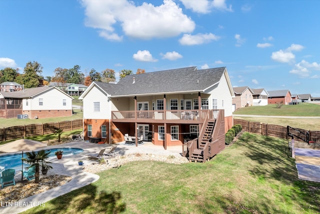 back of property with a lawn, a patio area, and a pool side deck