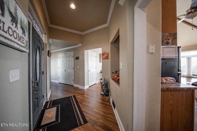 corridor with dark wood-type flooring and crown molding